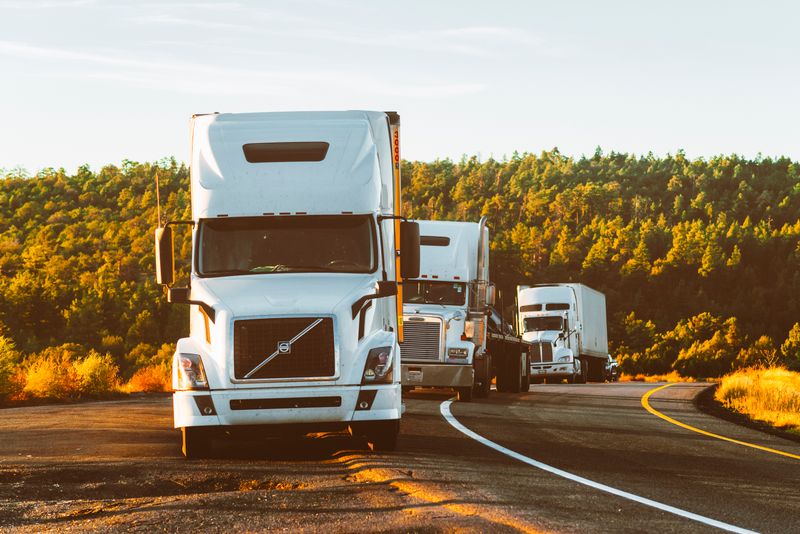 Semi trucks on a highway at sunset